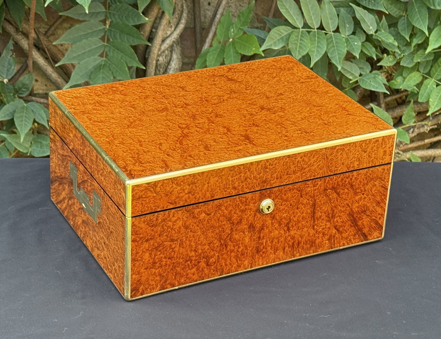 Oblique front view of an antique jewellery box in amboyna, by Edwards.