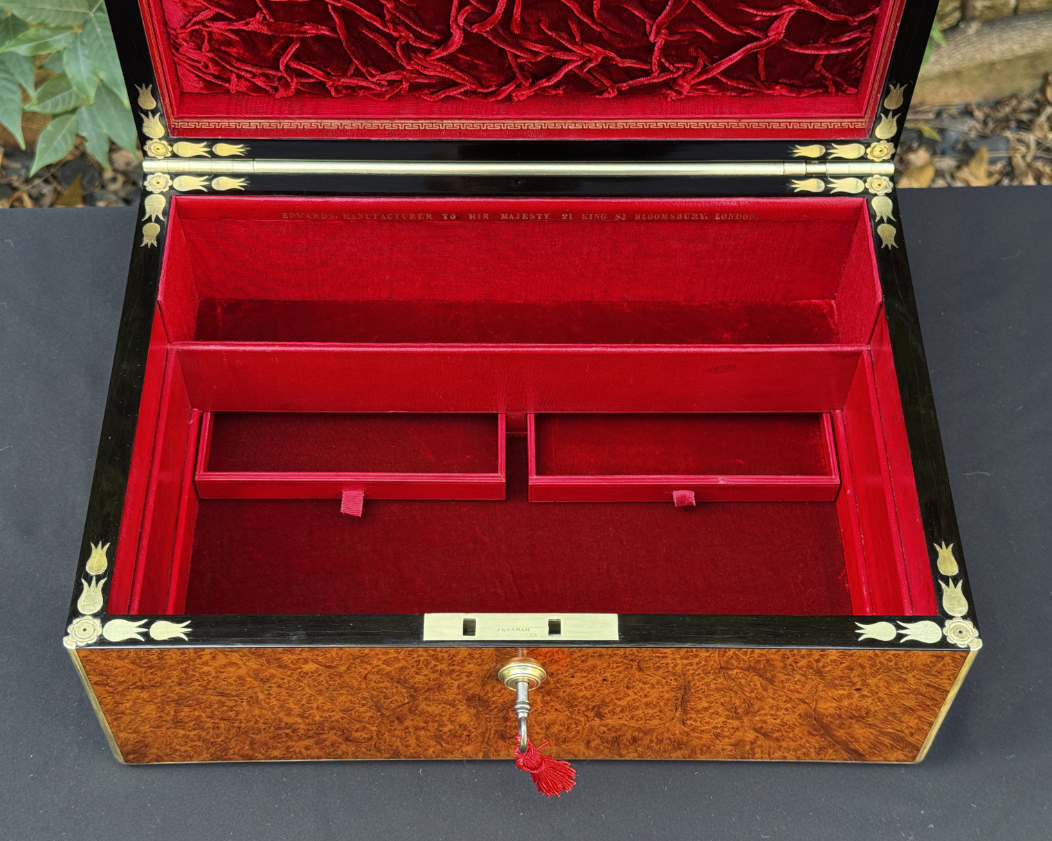 Overhead interior view of an antique jewellery box in amboyna, by Edwards, with all three trays removed and concealed drawers on display.