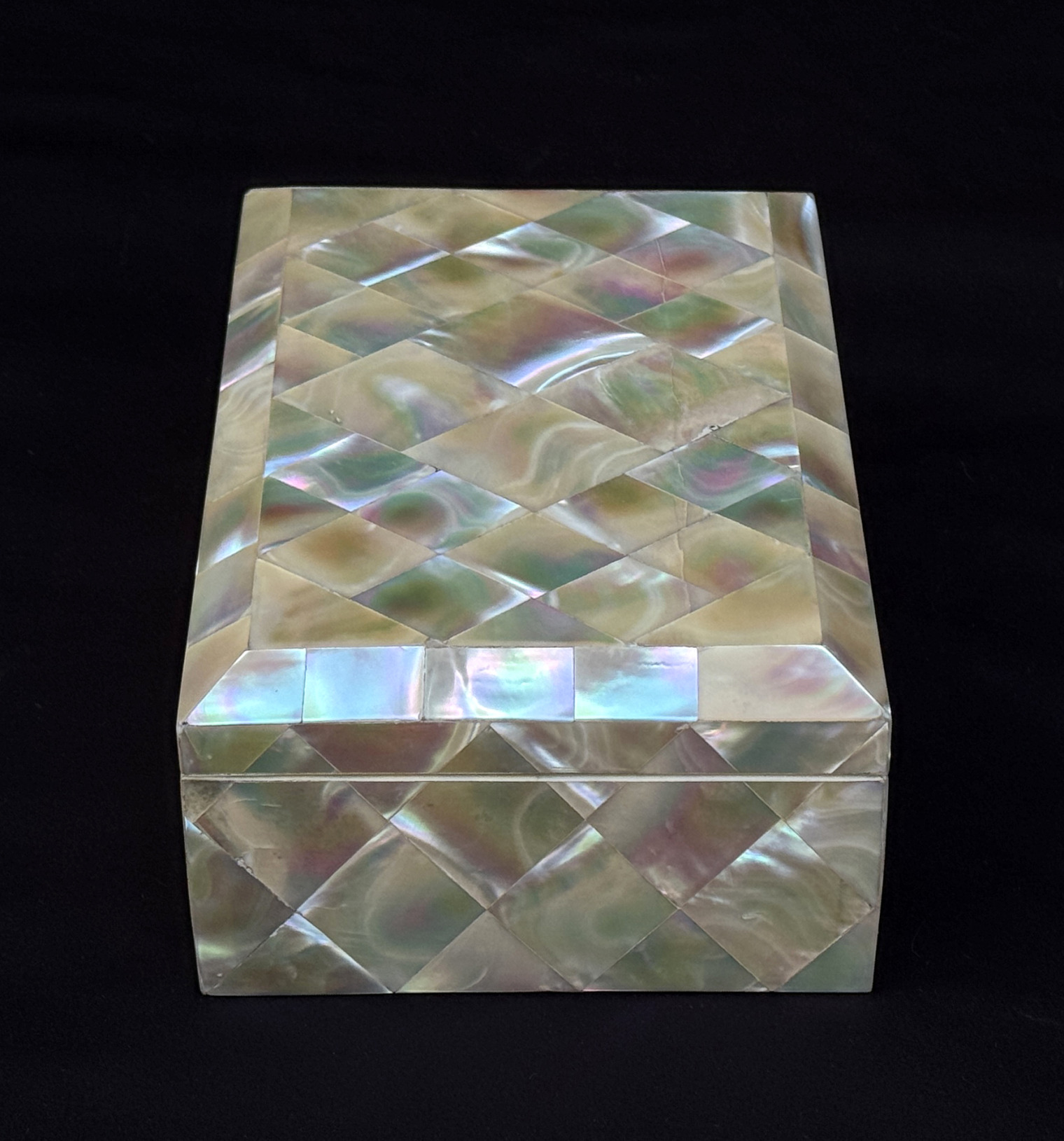 Left side view of an antique mother of pearl inlaid jewellery box.
