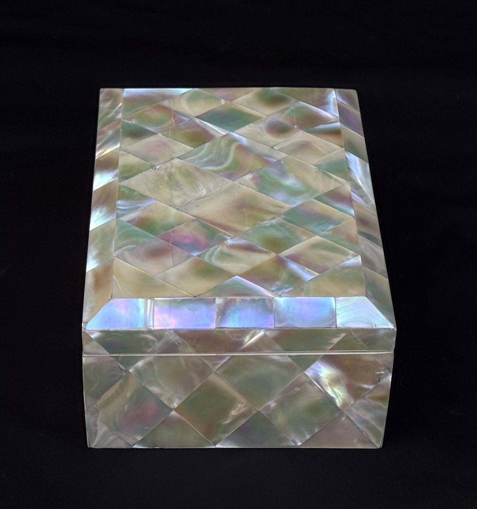 Right side view of an antique mother of pearl inlaid jewellery box.