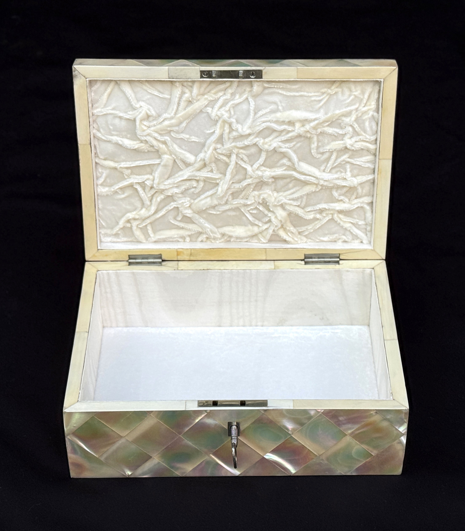 Front interior view of an antique mother of pearl inlaid jewellery box.
