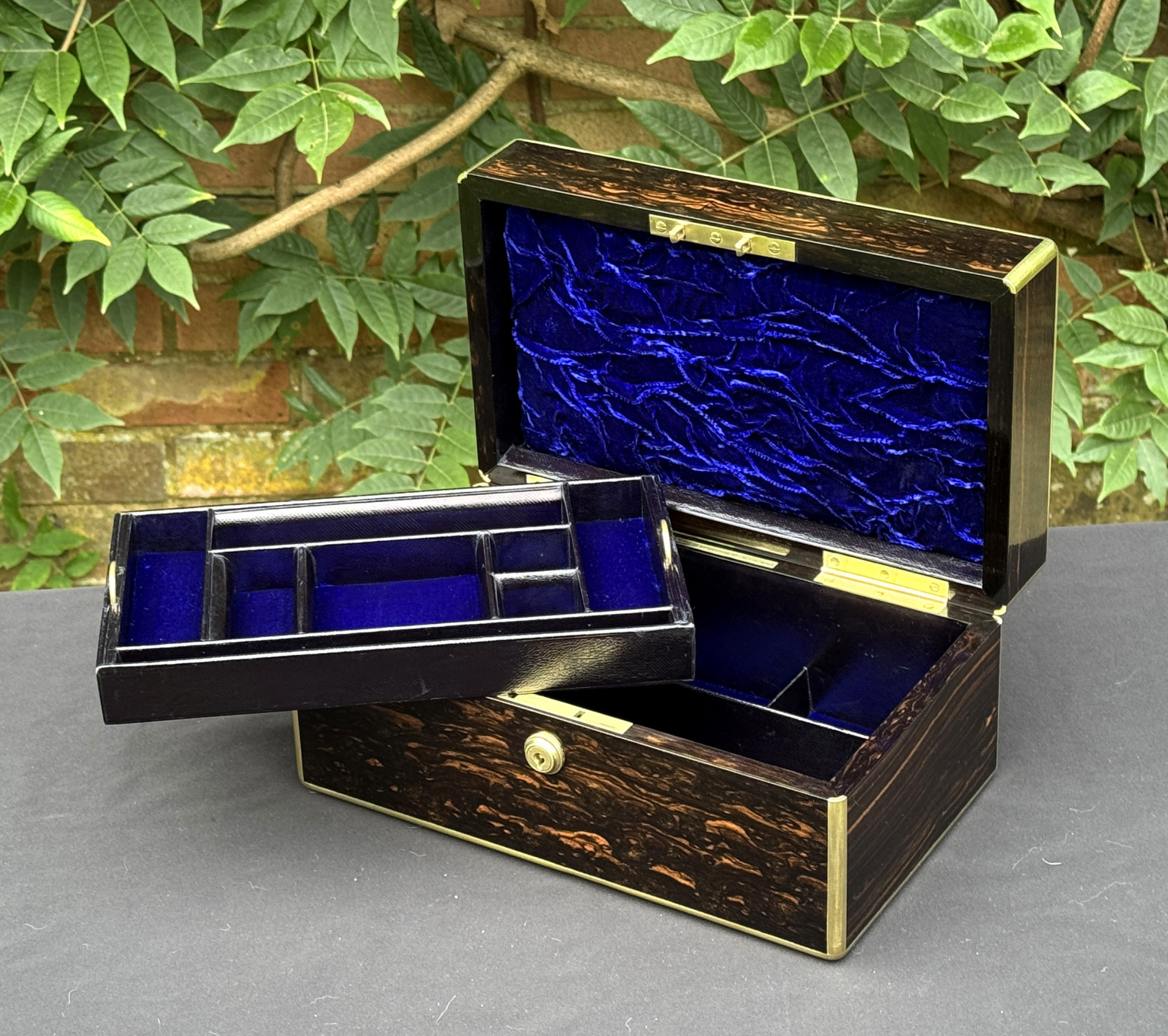 Front right internal view of an antique gentleman's travelling jewellery box in coromandel, by Houghton & Gunn, with jewellery tray removed.
