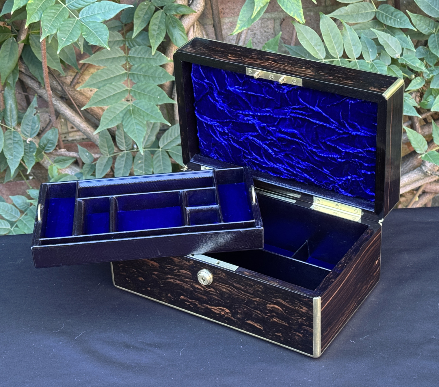 Front right internal view of an antique gentleman's travelling jewellery box in coromandel, by Houghton & Gunn, with jewellery tray removed.