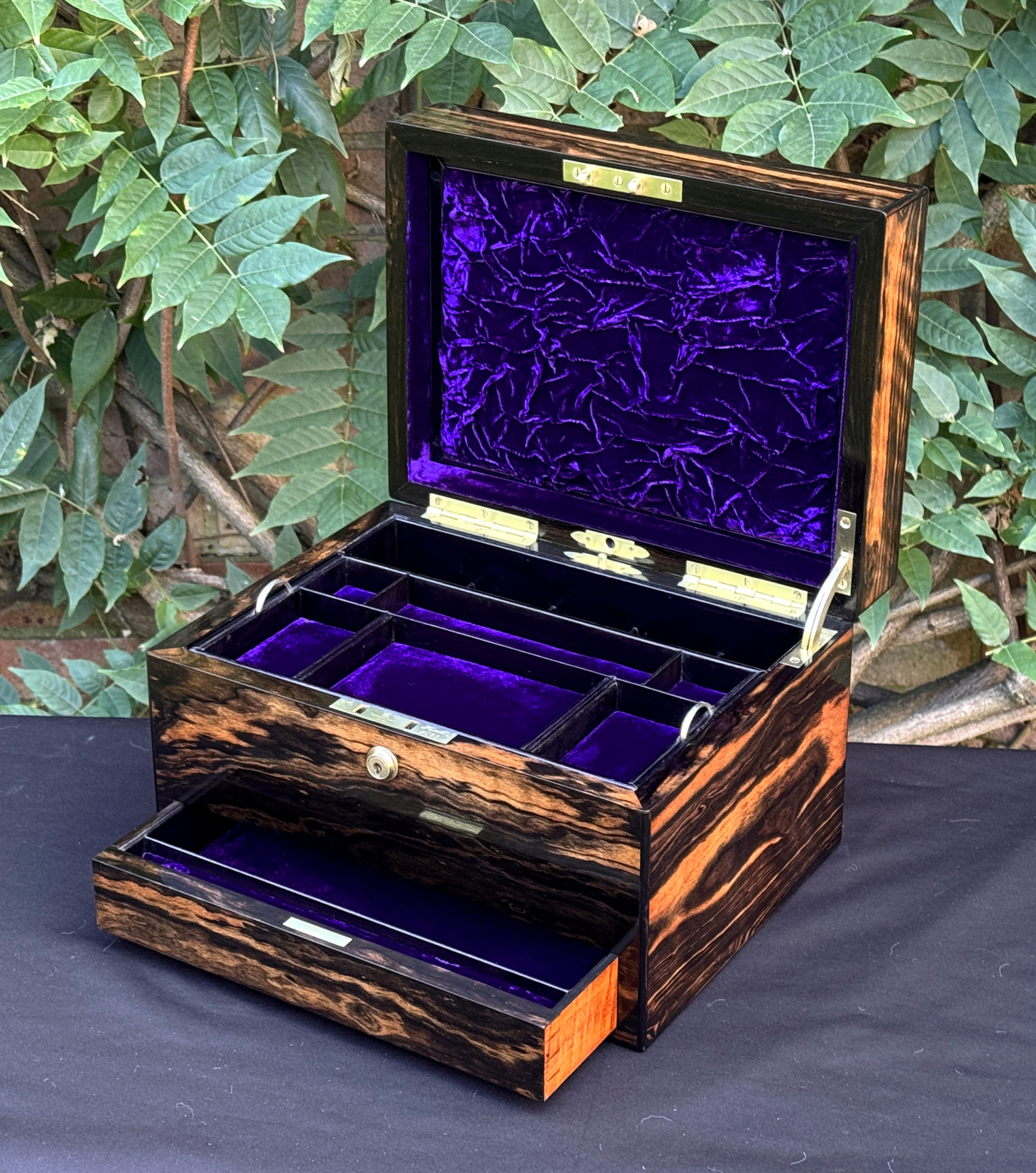 Front right interior view of an antique jewellery box in calamander, by George Betjemann & Sons, with lower drawer extended.