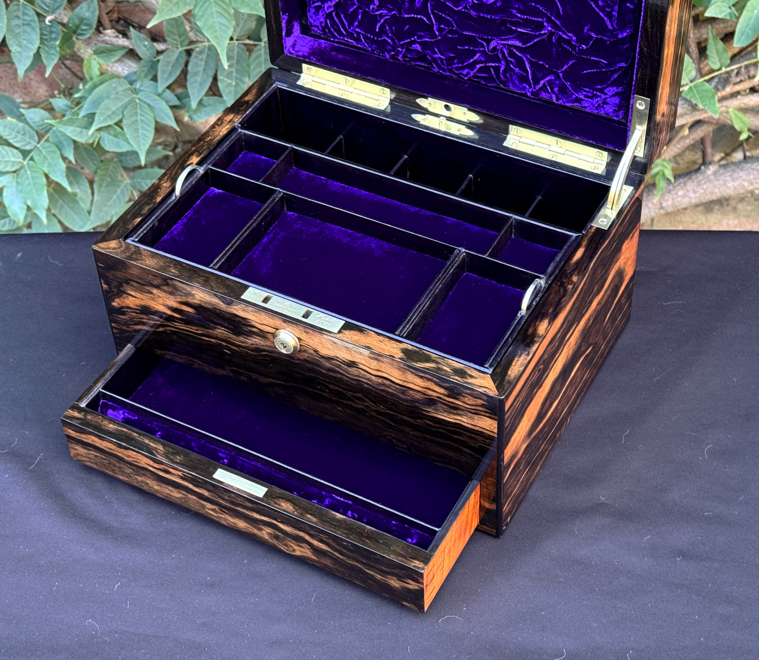 Closer interior view of an antique jewellery box in calamander, by George Betjemann & Sons, with lower drawer extended.