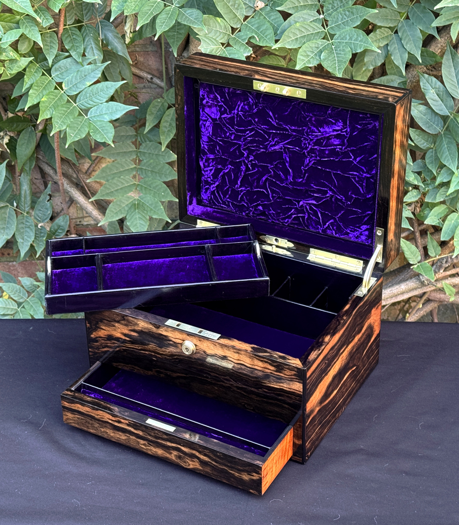 Front right interior view of an antique jewellery box in calamander, by George Betjemann & Sons, with lower drawer extended and tray removed.