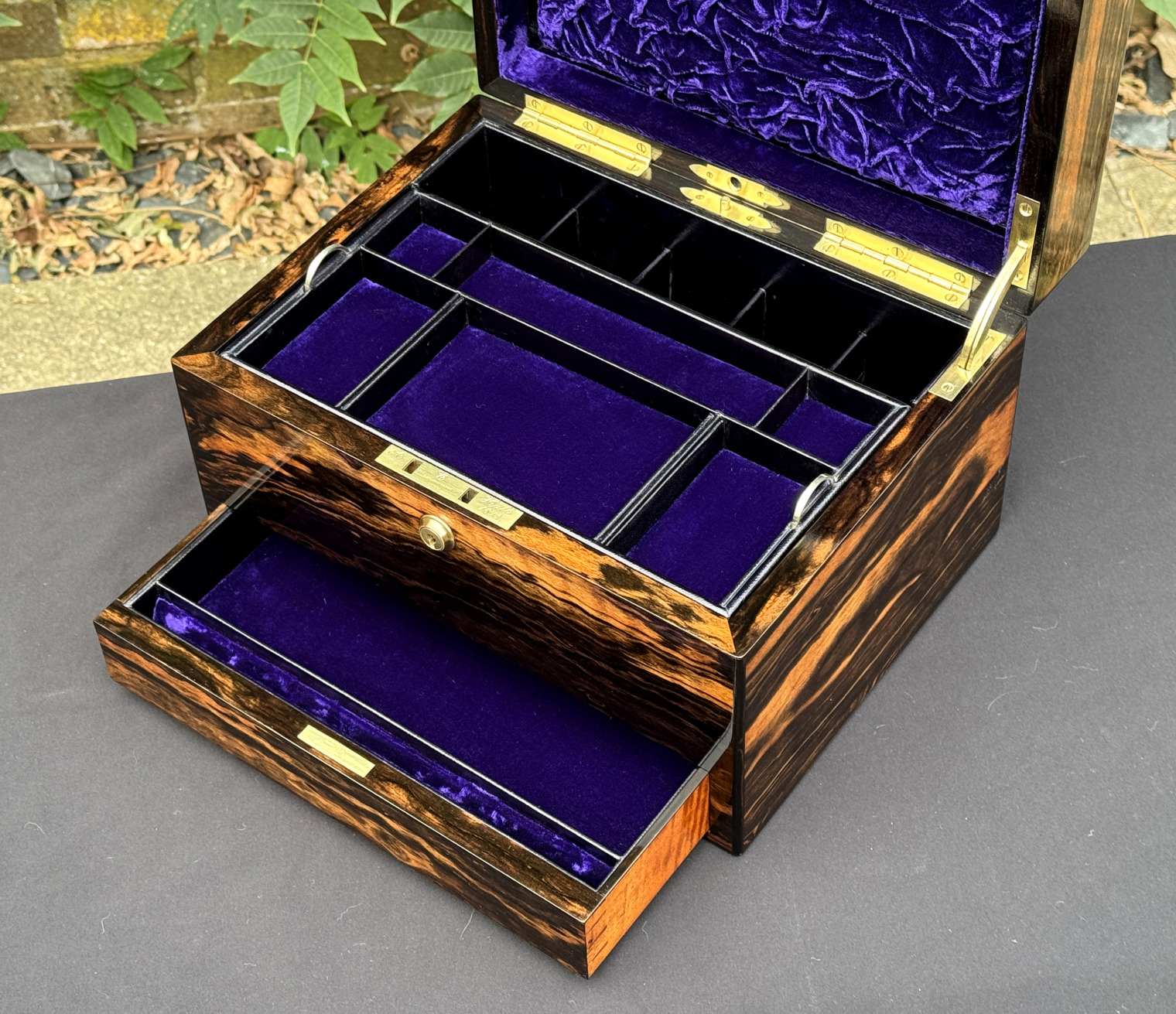 Closer interior view of an antique jewellery box in calamander, by George Betjemann & Sons, with lower drawer extended.