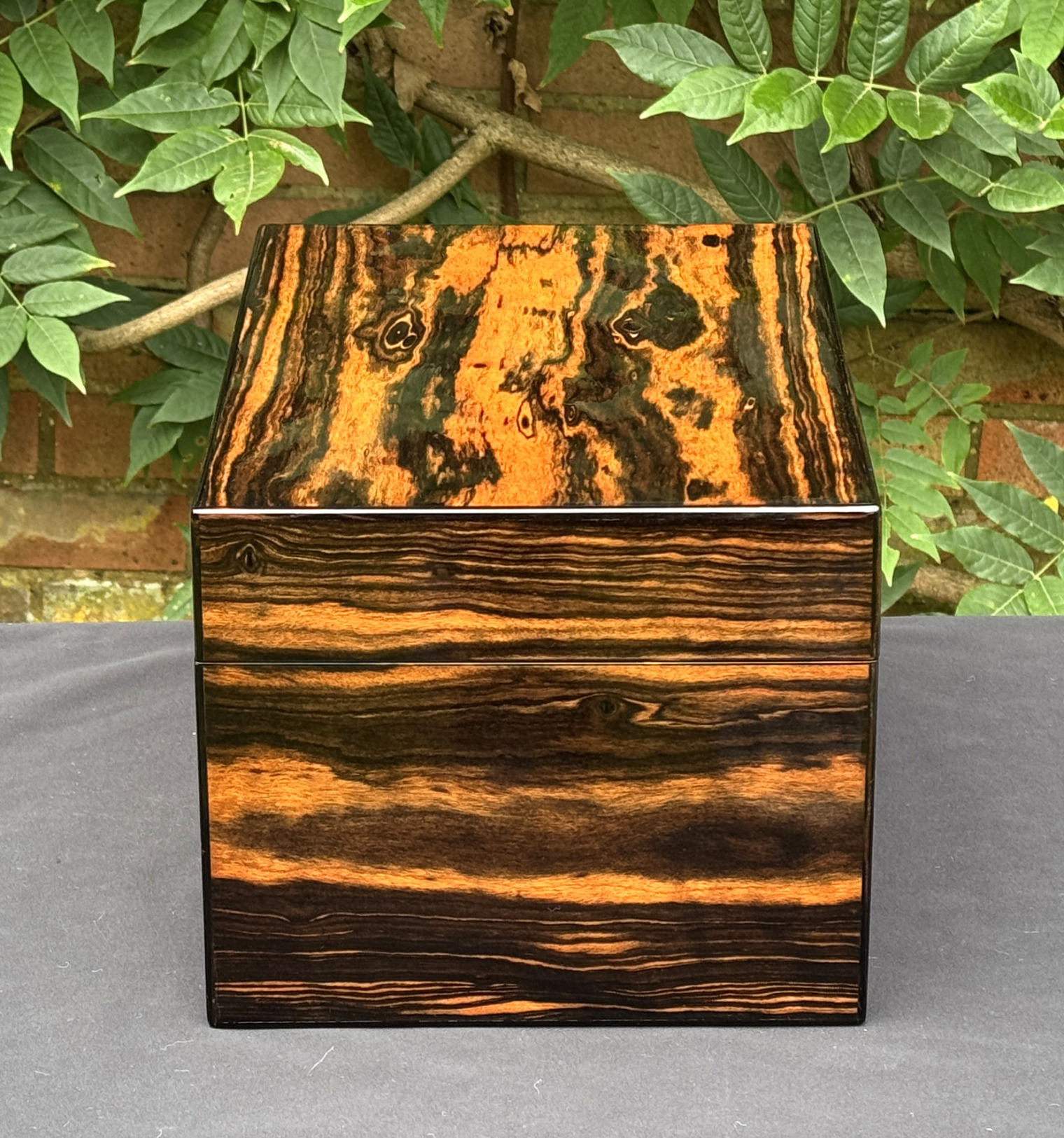 Left side view of an antique jewellery box in calamander, by George Betjemann & Sons.