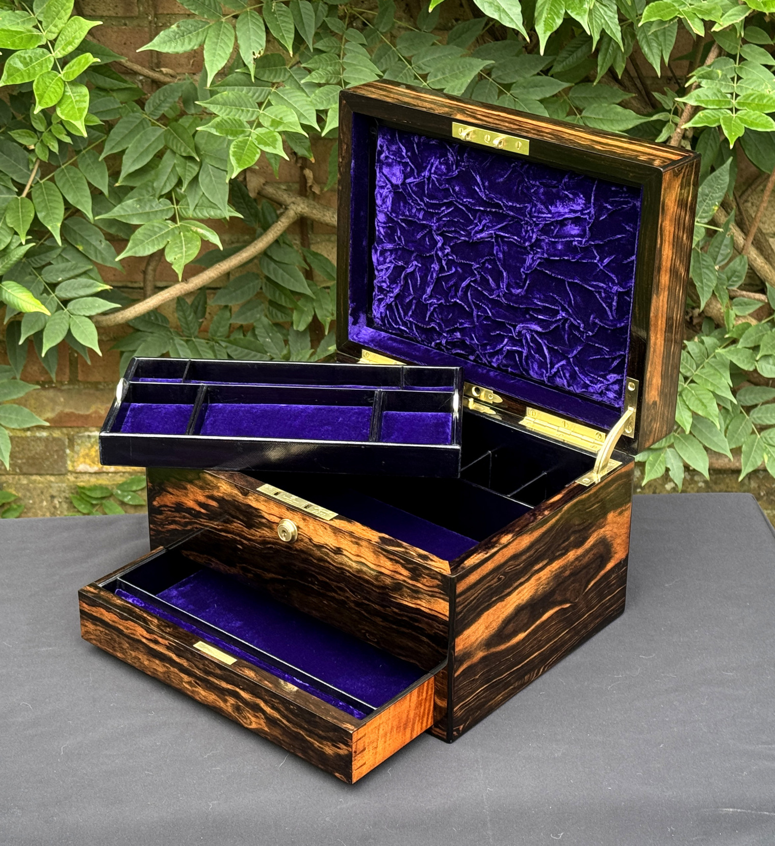 Front right interior view of an antique jewellery box in calamander, by George Betjemann & Sons, with lower drawer extended and tray removed.