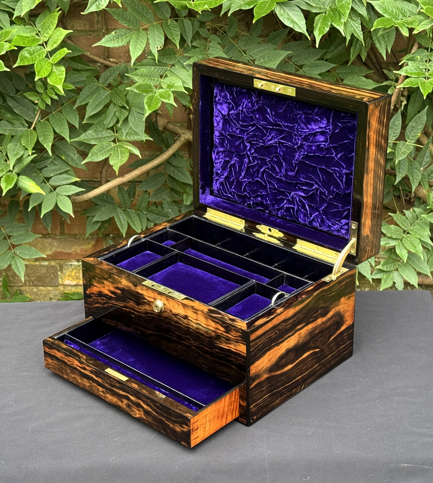 Front right interior view of an antique jewellery box in calamander, by George Betjemann & Sons, with lower drawer extended.