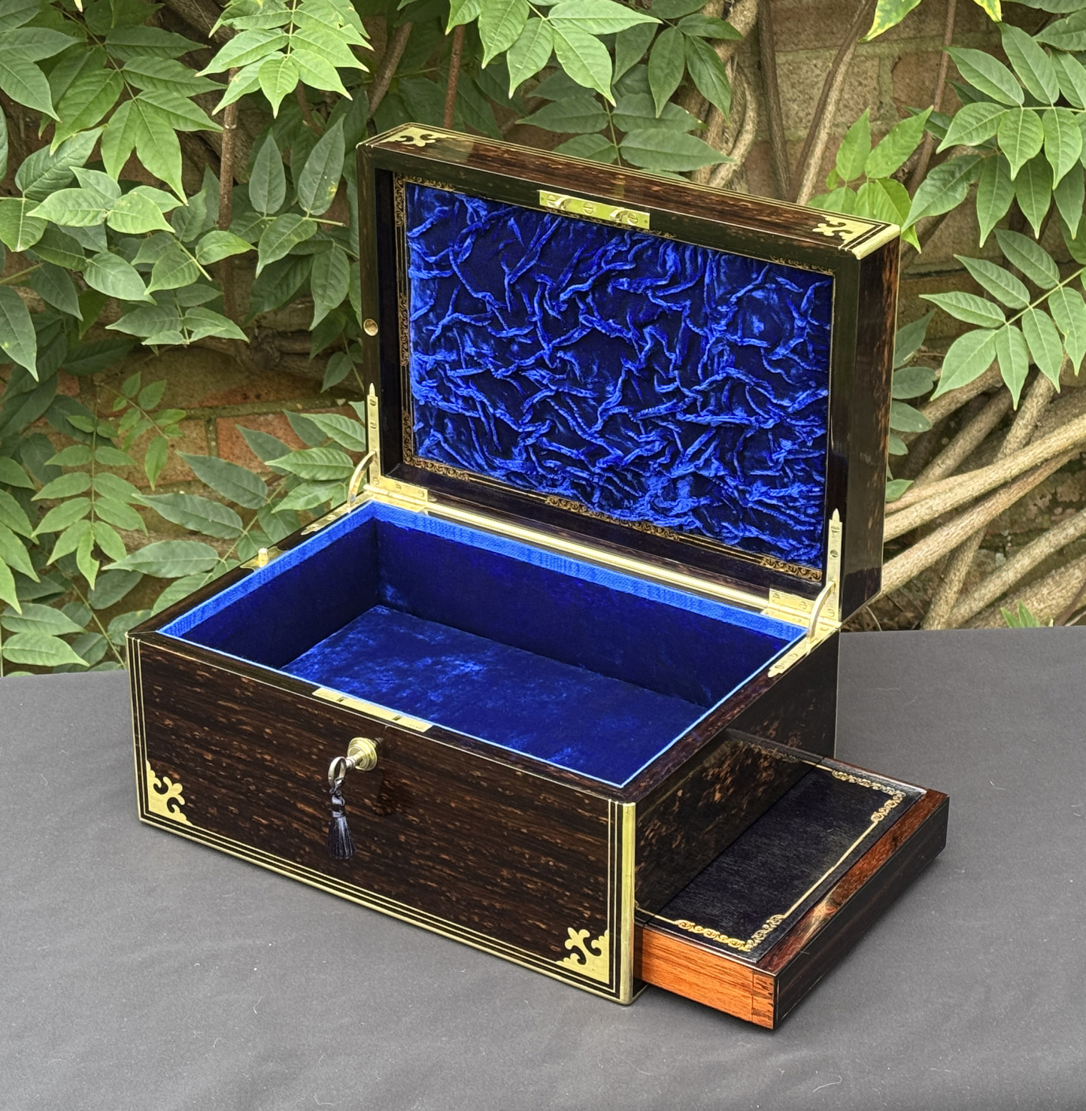 Front right interior view of an antique jewellery box in coromandel, by Thomas Dalton, with side drawer partially extended.