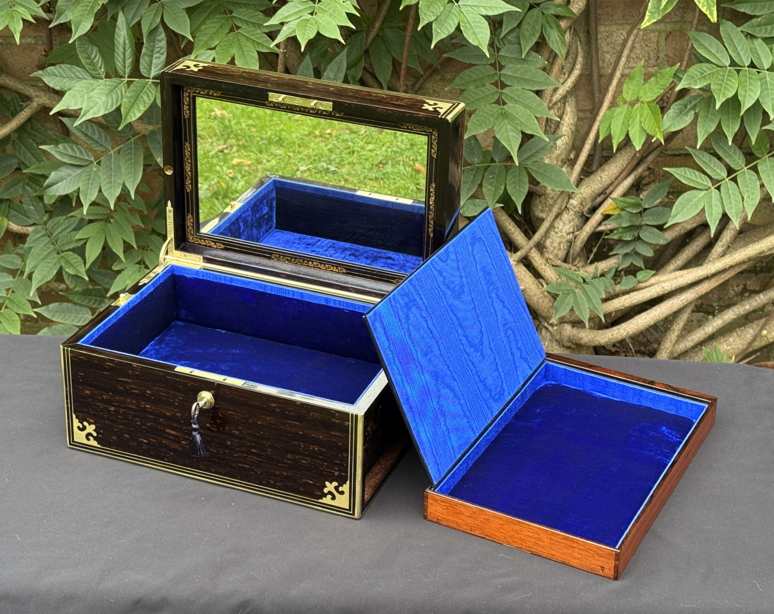 Front right interior view of an antique jewellery box in coromandel, by Thomas Dalton, with side drawer removed and its hinged-lid opened.