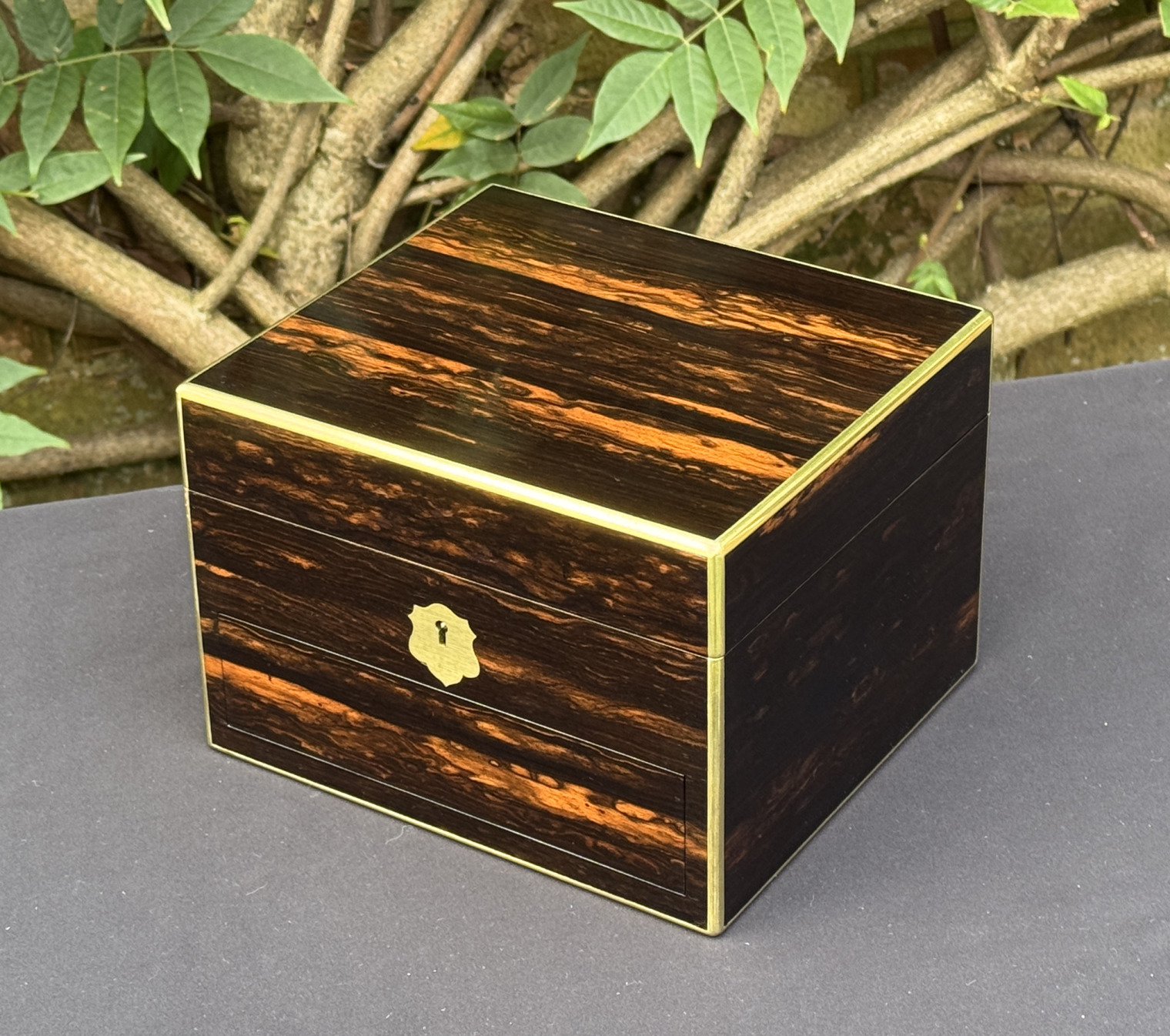 Front right view of a miniature antique jewellery box in coromandel, by George Betjemann & Sons.