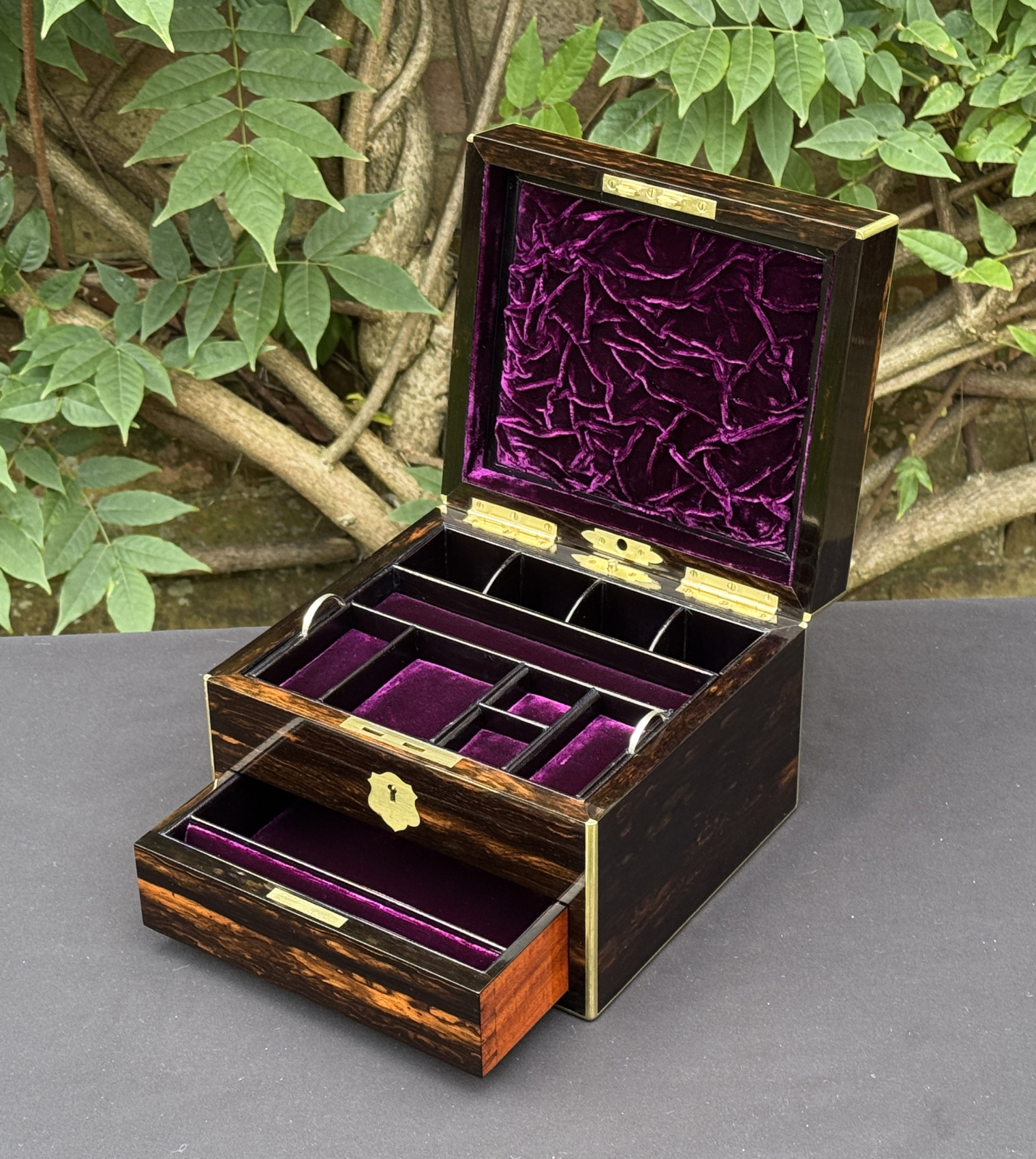 Front right interior view of a miniature antique jewellery box in coromandel, by George Betjemann & Sons, with lower drawer extended.
