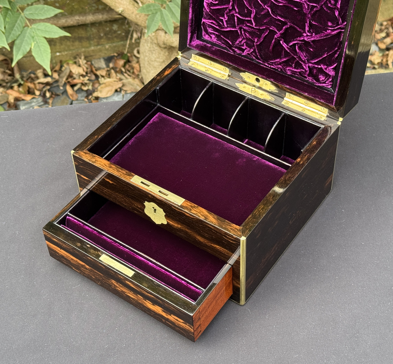 Closer interior view of a miniature antique jewellery box in coromandel, by George Betjemann & Sons, with lower drawer extended and jewellery tray removed.
