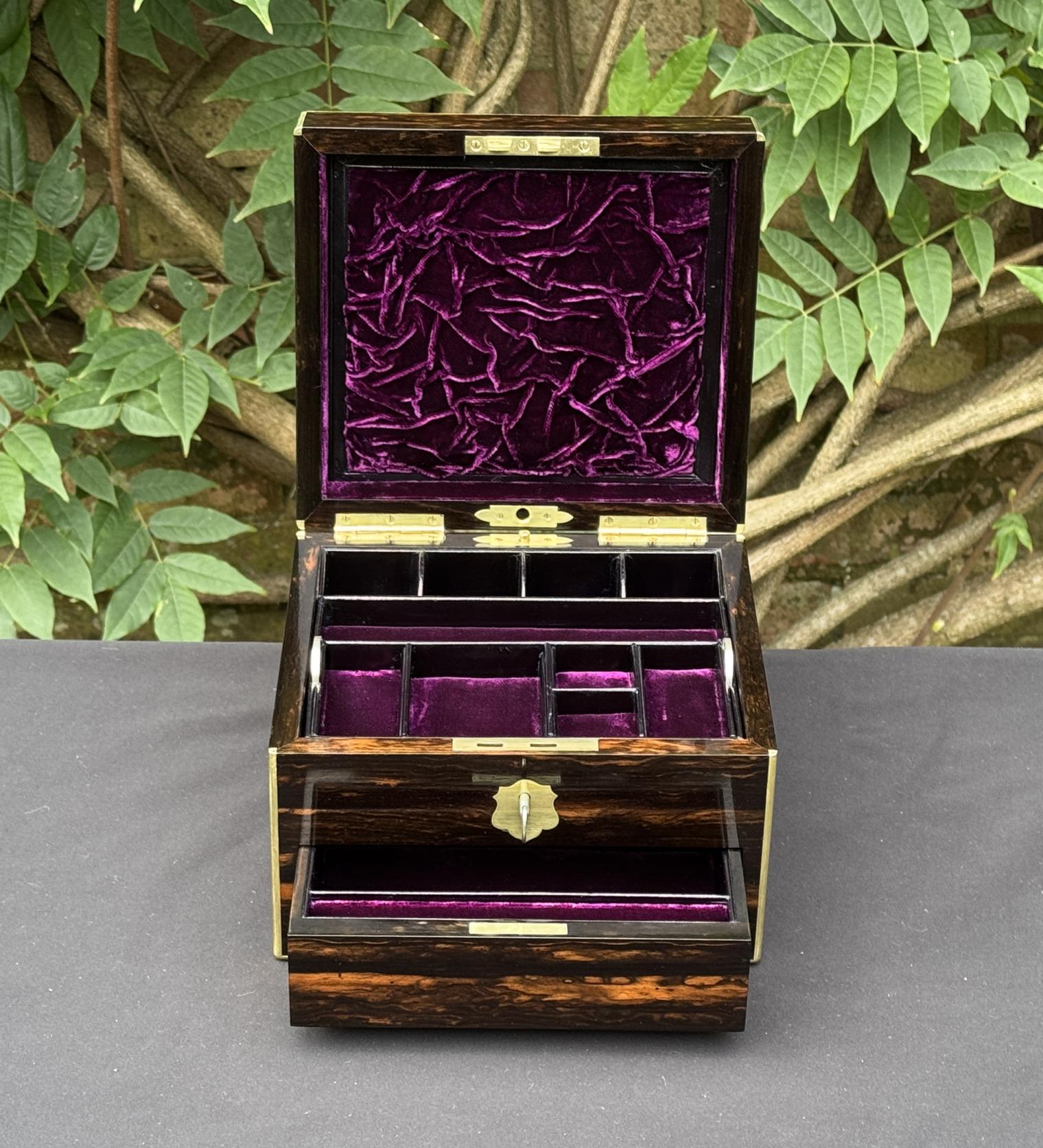 Front interior view of a miniature antique jewellery box in coromandel, by George Betjemann & Sons, with lower drawer extended.