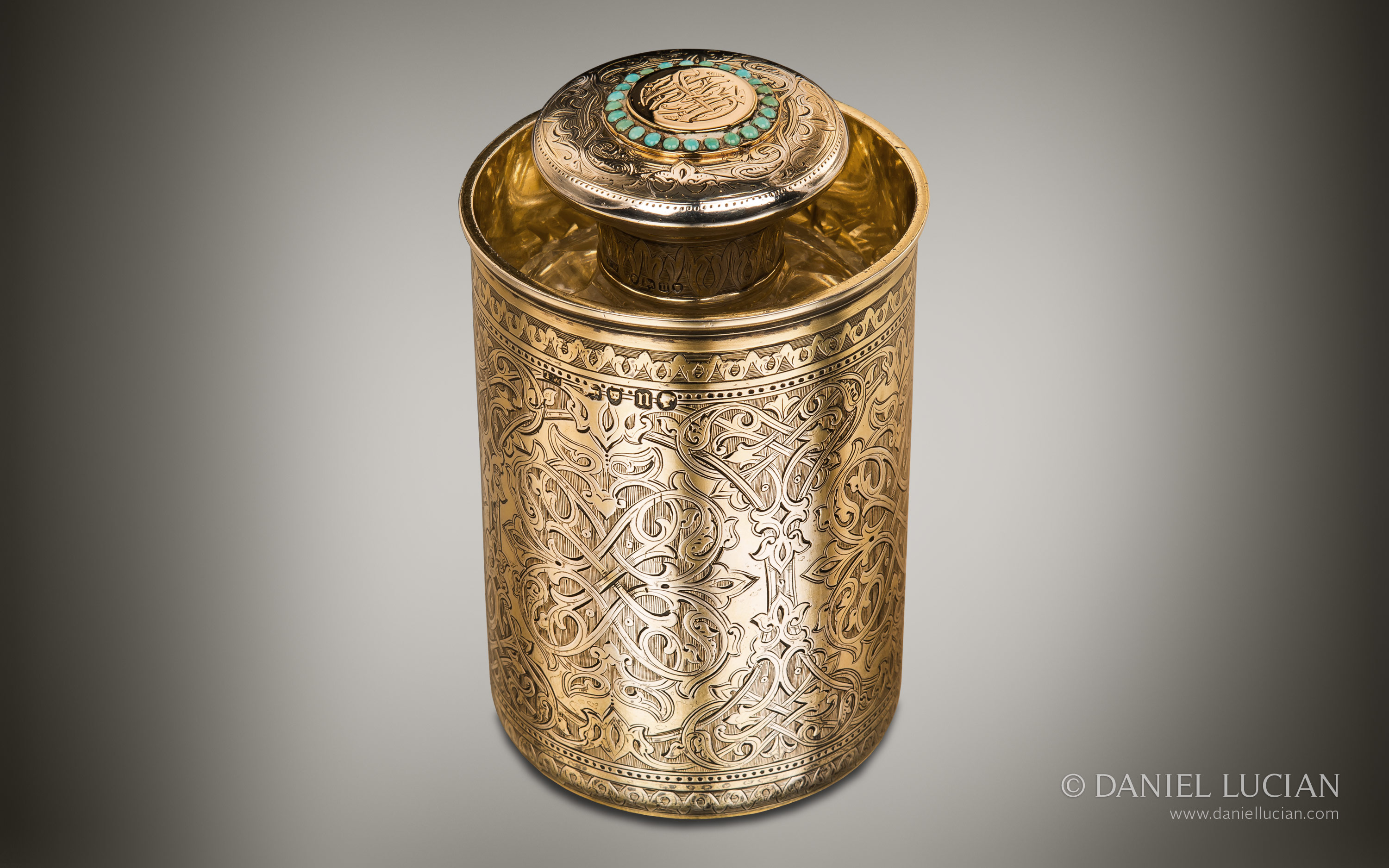 Silver-gilt Asprey spirit bottle with gold inset and turquoise decoration.