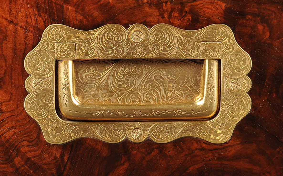 Sculpted and engraved brass handle from an antique jewellery box in figured walnut.