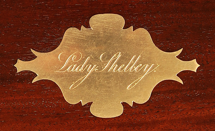 Brass escutcheon bearing the engraved name 'Lady Shelley' from a mahogany antique jewellery box.