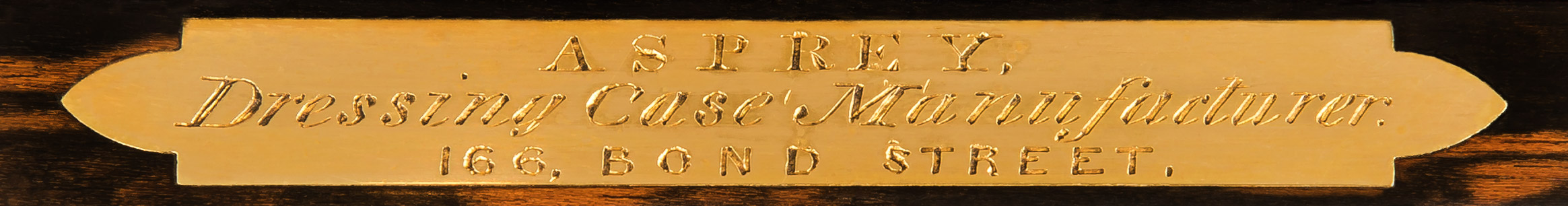 An inlaid brass plate on the foremost internal rim of the box is engraved with ‘Asprey – Dressing Case Manufacturer – 166 Bond Street’.